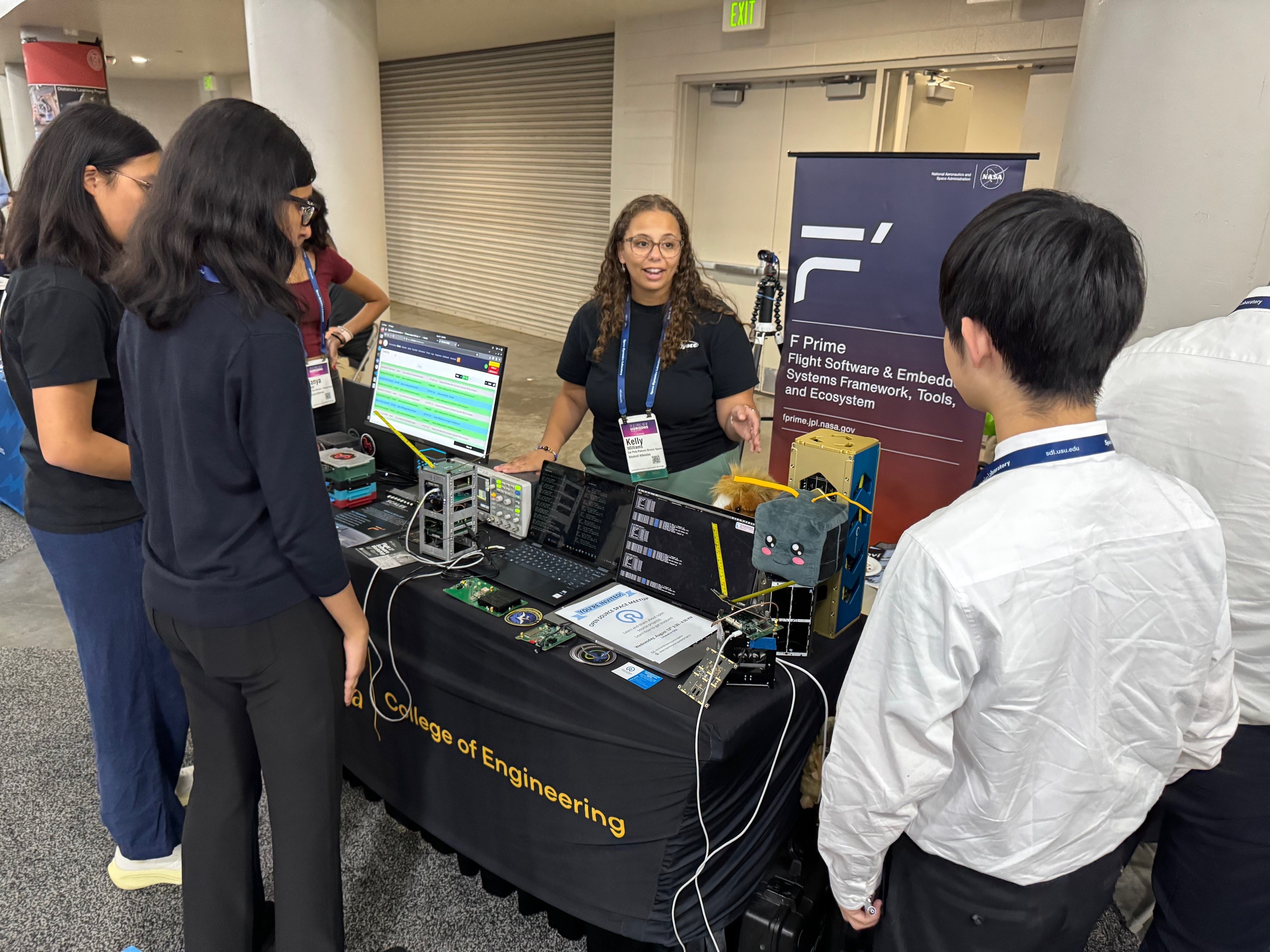 Kelly Williams speaking with people at the F Prime SmallSat table