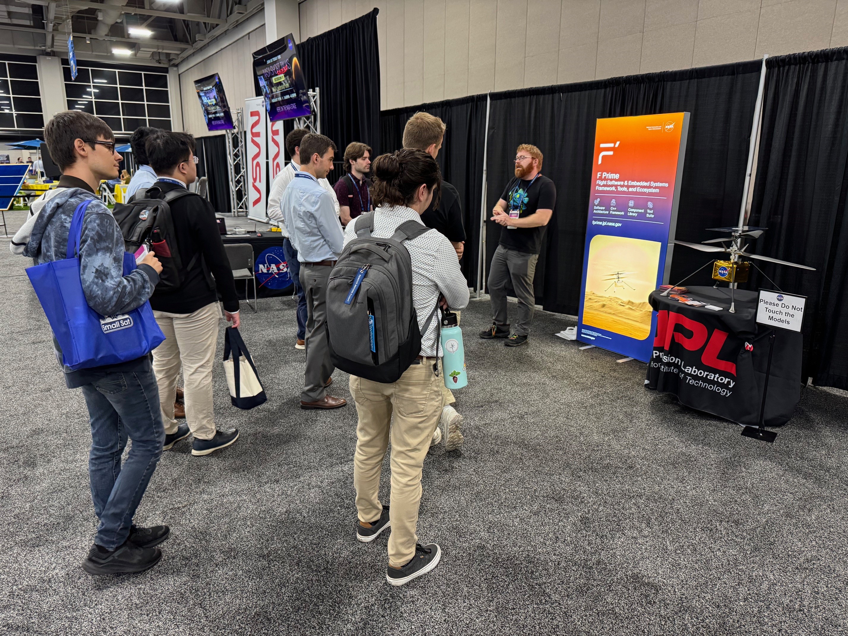 F Prime Cognizant Engineer Michael Starch speaking with people in the NASA space at SmallSat
