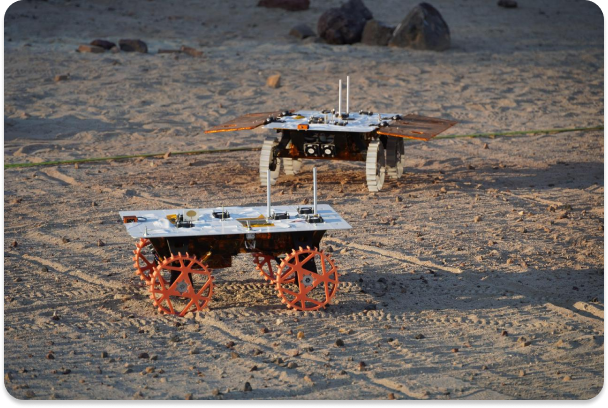 Two full-scale development model rovers are tested in JPL's Mars Yard in August 2023 as part of NASA's CADRE tech demo. These tests confirmed the project's hardware and software can work together to accomplish key goals.